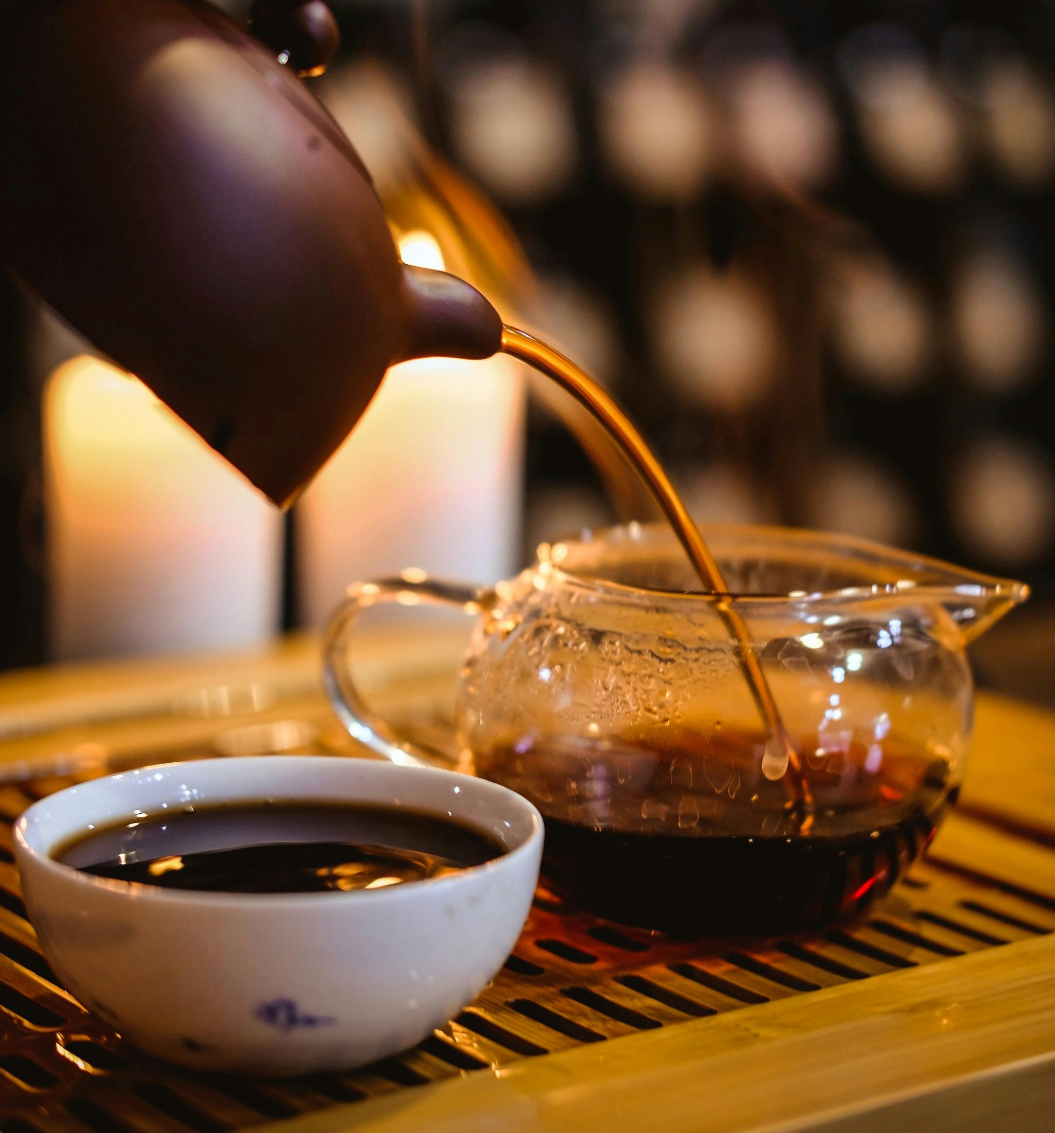 Background image - ripe puer tea pouring from brown clay teapot